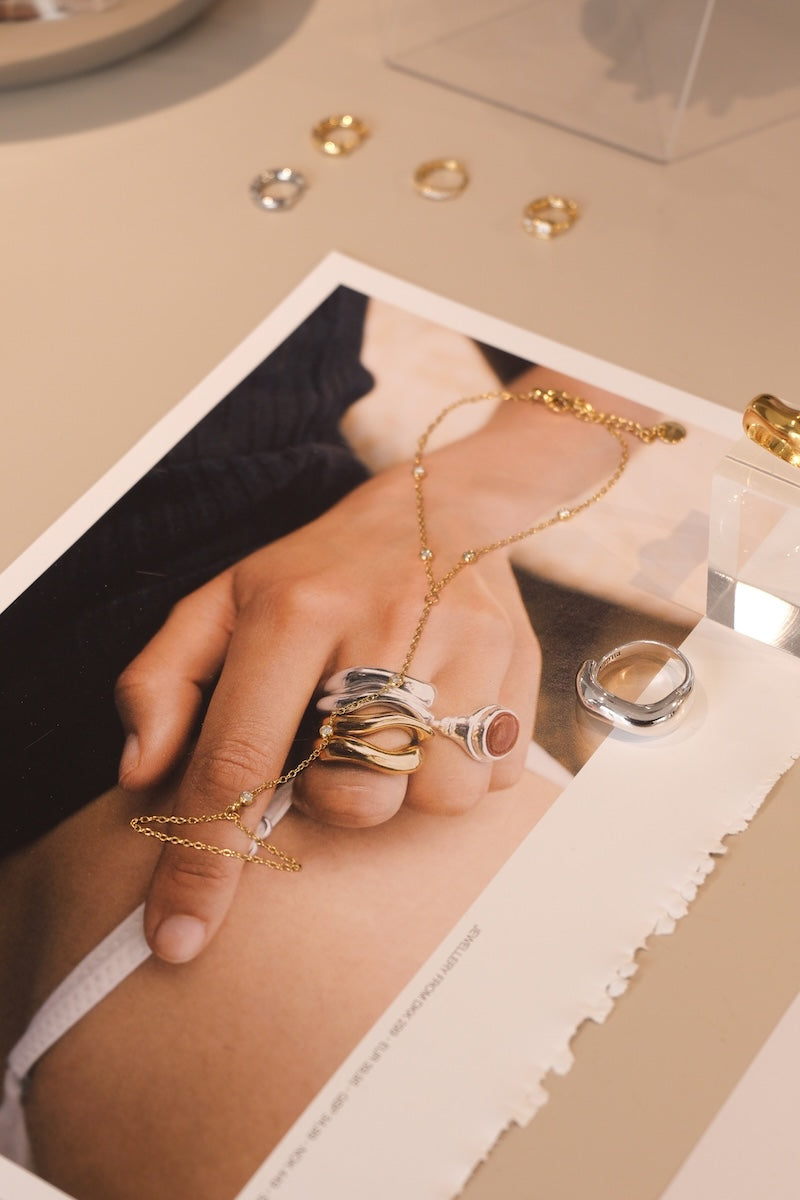 zu sehen ist eine handkette in gold die auf einem Tisch ausgelegt ist