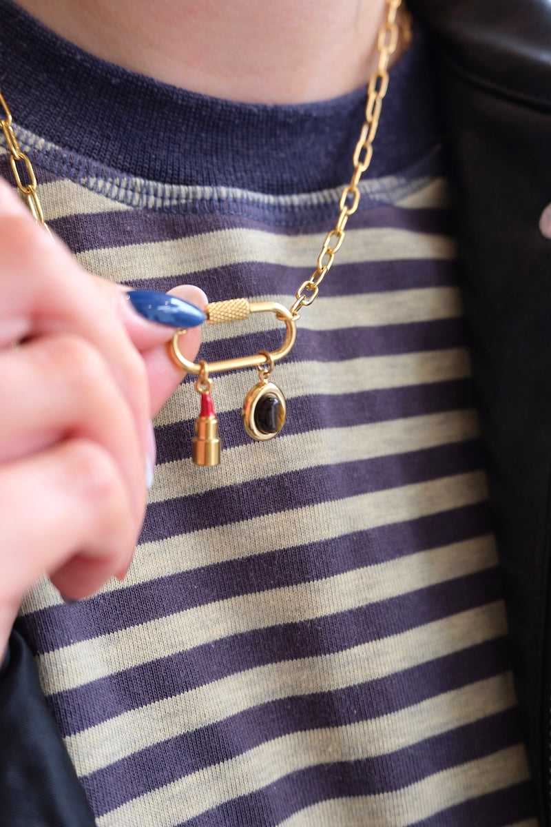 runder gold charm mit großem braunen stein in der mitte kombiniert mit einer lock kette und einem Lippenstift charm