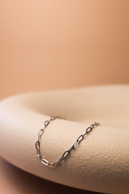 silbernes link armband liegt auf weißer edlen schale