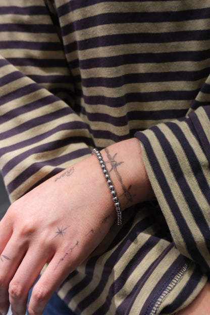silbernes armband mit kugel optik getragen an Frau mit streifen Pullover 