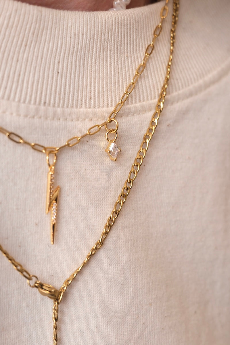 zu sehen ist ein Diamant charm der an einer feinen gold kette befestigt ist