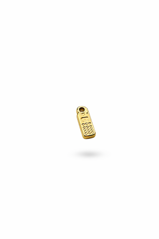kleiner Anhänger aus goldfarbigem Edelstahl vor einem schlichten, hellen Hintergrund. der charm hat die form eines alten mobiltelefon mit rechteckiger Grundform 