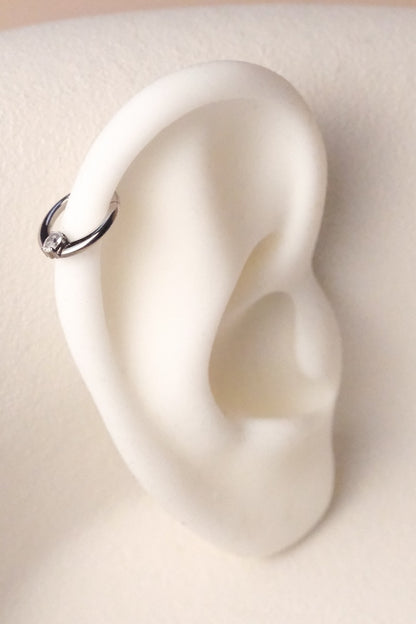 silberner piercing ring an weißem Aussteller dran
