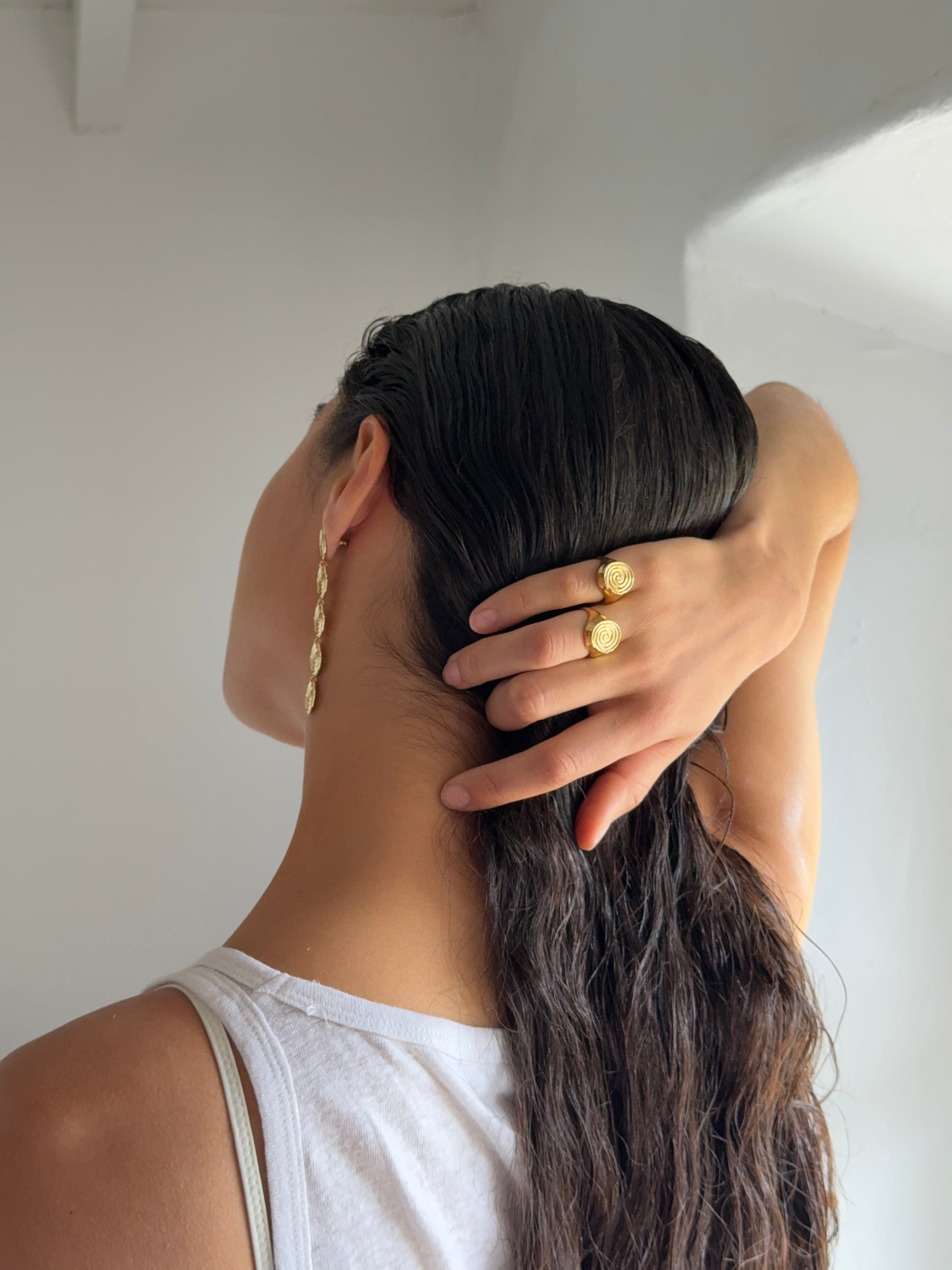 goldener runder ring mit massiver optik getragen von Frau mit schwarzen haaren