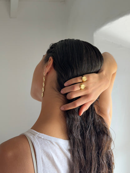 goldener runder ring mit massiver optik getragen von Frau mit schwarzen haaren