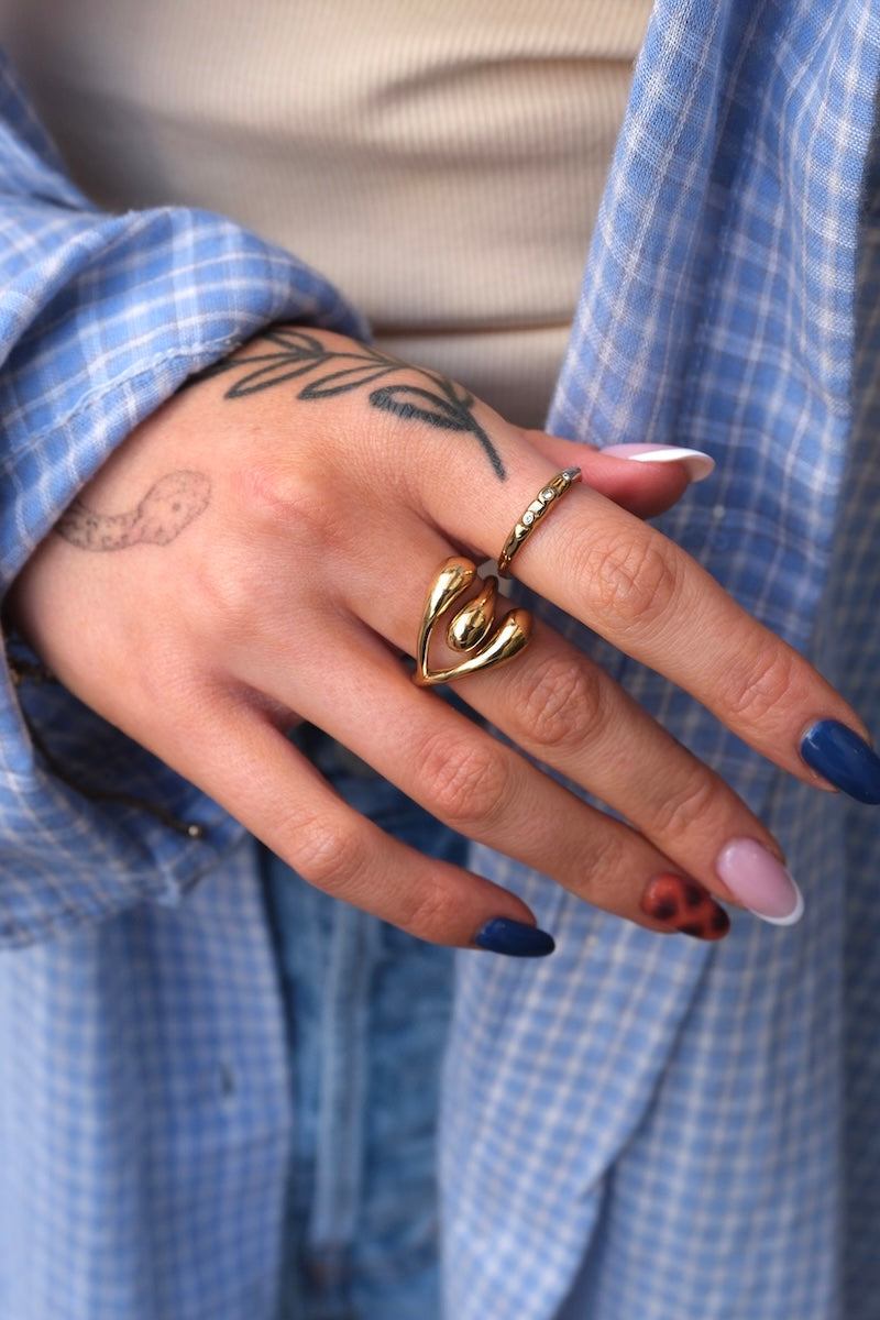 ein feiner und ein dickerer ring getragen an hand mit bunten nageln 